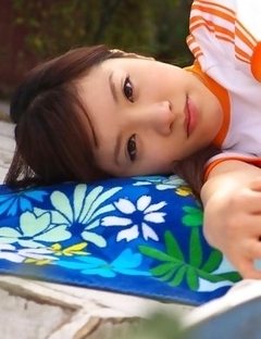 Cocoro Amachi in shorts plays with ball and bike in garden